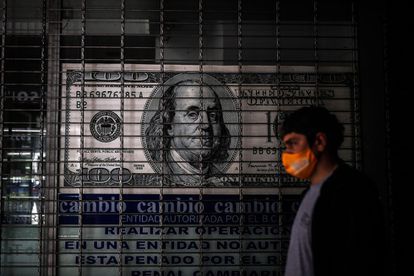 Una persona camina frente a una casa de cambio, en Buenos Aires (Argentina).