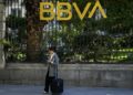 Una mujer en frente de un edificio del BBVA en Madrid.