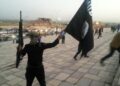 Un miliciano levanta una bandera del Estado Islámico, tras la toma de Mosul en junio de 2014.