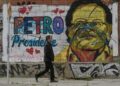 Un hombre pasa junto a un mural que representa al candidato Gustavo Petro, en Bogotá.
