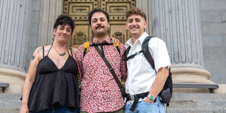 El presidente de No es terapia, Saúl Castro (en el medio), con dos víctimas de falsas terapias de conversión para personas LGTBIQ+, Laura y Xavi Martínez Cal, a las puertas del Congreso el día que se penalizaron estas prácticas.